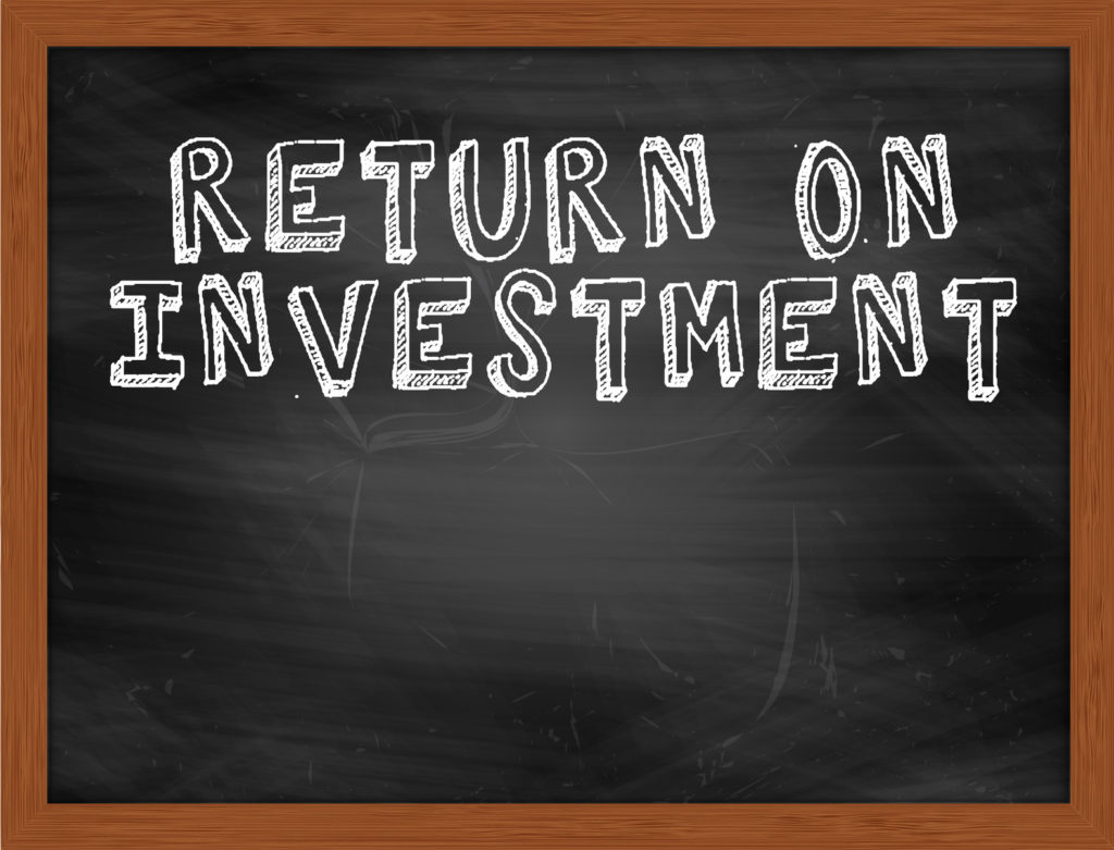 RETURN ON INVESTMENT handwritten chalk text on black chalkboard